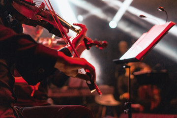 Red colored violin concert at bright rock stage