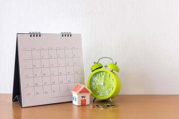 Calendar and house on table. Day of buying or selling a house or payment for rent or loan.
