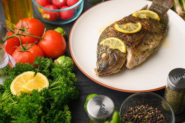 Stewed fish with lemons and fresh vegetables. Delicious and healthy food.