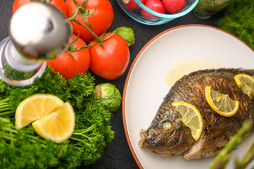 Ready cooked fish on a background with vegetables. Cooking recipes, restaurant business, culinary recipes