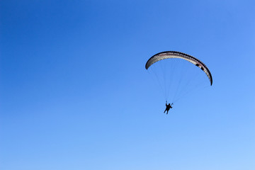 paraglider flying in blue sky on valleys landscape in Indonesia