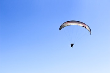 a paraglider flying in blue sky landscape in Indonesia