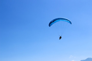 paraglider flying in blue sky on valleys landscape in Indonesia
