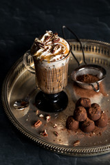 Hot beverage with whip cream and sprinkled cocoa.