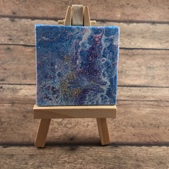 easel with canvas on wooden background