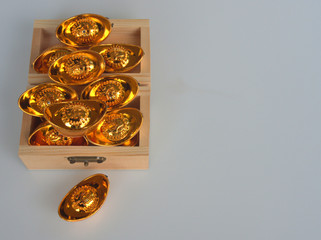 The small gold ingots as ancient China money are stored in the wooden box, that  isolated on the white background. 