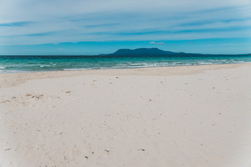 Spring beach in Tasmania, Australia looking pristine and deserted with white sand and turquoise water