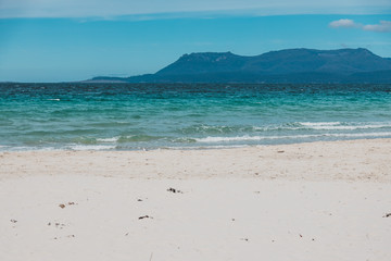 Spring beach in Tasmania, Australia looking pristine and deserted with white sand and turquoise water