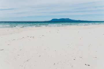 Spring beach in Tasmania, Australia looking pristine and deserted with white sand and turquoise water