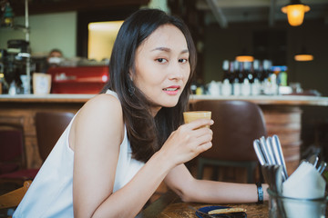 Asian business women drinking latte coffee sitting in cafe