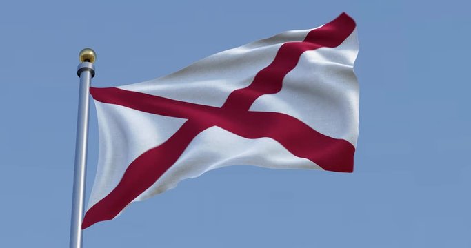 flag of Alabama blowing in the wind in front of a blue sky