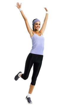 Full body of happy african american woman jumping or doing fitness aerobics exercise, isolated against white background. Sporty model with raised up arms, in sportswear, at studio picture.