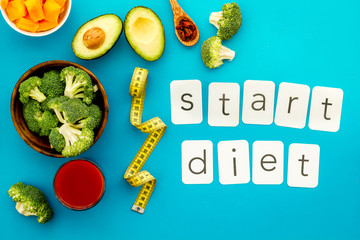 Start diet text near healthy food on blue background top view