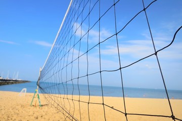 Close up of volleyball net with sea beach and blue sky in summer. Nature, outdoor and sport concept.