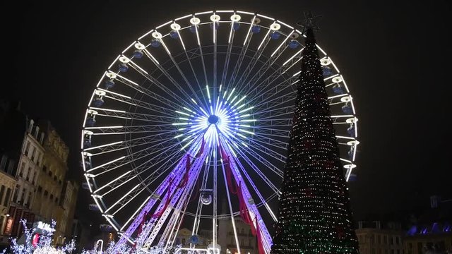 ferris wheel in lille turning behind christmas tree in grand place