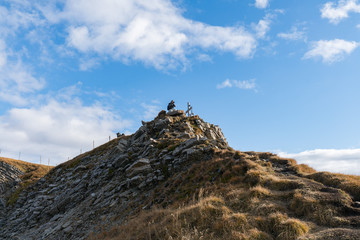 Tourists standing on the edge of cliffs and rocks while taking photos on the top of Seceda in Dolomites, South Tyrol, Italy