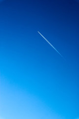 airplane trail in the bright azure winter sky