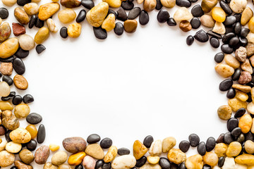 Summer trip to sea concept. Stones on white background top-down frame copy space