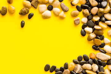 Sea stones background with yellow copy space top-down frame