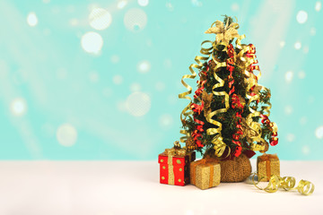 Decorated Christmas tree with gift boxes and snow lights bokeh, free copy space.