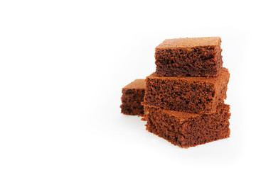 Pieces of traditional Belgian chocolate biscuit brownie lies pyramid on a white background. Horizontal photo with copy space.