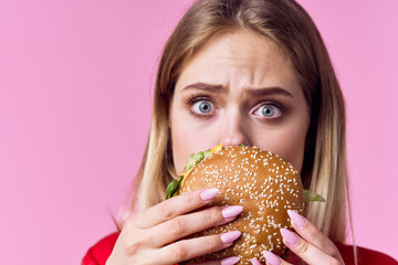 woman eating hamburger - obrazy, fototapety, plakaty