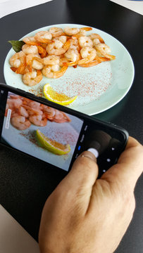 take a picture of food on a black background. a blogger is running an overview of the restaurant concept. Fresh delicious boiled peeled shrimp.