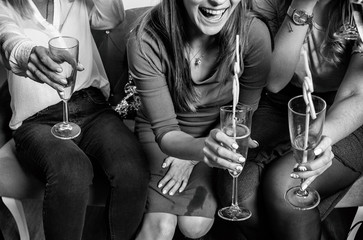 Group shot of young women celebrating Christmas or Birthday. Hen party. Clink glasses. Black and white photo