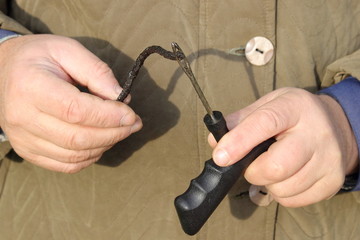 A repairman hands inserts a tyre repair threadlock into a needle tool close up, car tire self repair