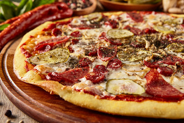 Meat and vegetable pizza on wooden table