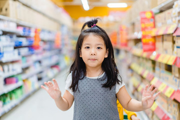 Surprised and excited face of happy little asian girl in supermarket with mom.Little girl open mouth in hypermarket with family.wow emotion in kid.