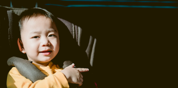 Smiling Asian Child Toddler Boy Pointing Finger To Left Side For Good Drive Good Trip And Safe On The Road.Sitting And Buckle Up In The Car In The Seat For Children.