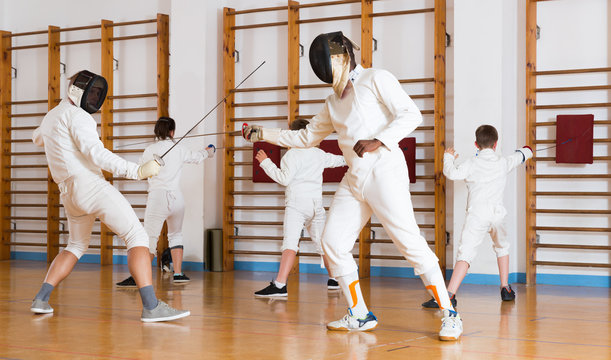 Smiling group  practicing fencing techniques