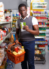 Man with cart shopping in store