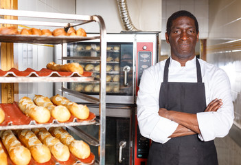 Confident baker near professional bread oven