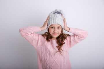 little girl in knitted winter hat on white background