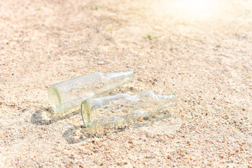 Fototapeta na wymiar Glass Bottles Isolated on Sand as for Environmental Pollution of Sea Concept