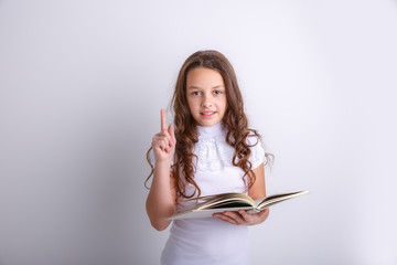 Teenage girl with a book in her hands on a white background. Shows emotions joy, surprise, sadness.