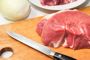 Slices of fresh raw meat on a cutting kitchen board. Cooking food