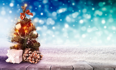 Beautiful decoration christmas tree on table with snow on blurred colorful bokeh background