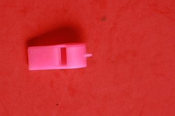 pink whistle shaped plastic toy in color background
