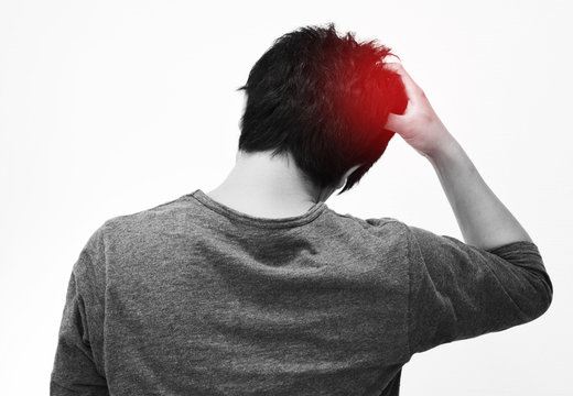 頭が痛い男性の後ろ姿