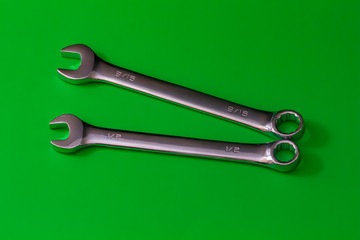 Pair of Steel Wrenches on Solid Green