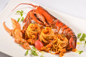Spaghettoni with Maine lobster and Bisque sauce on white plate