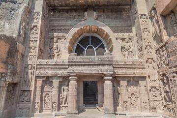 Fototapeta na wymiar Ornate entrance of the Buddhist chaitya (prayer hall), cave 19, carved into a cliff in Ajanta, Maharasthra state, India