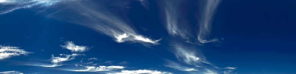 Nephology art. A beautiful sky cloudscape scene, with white cirrus cloud in a mid blue sky.