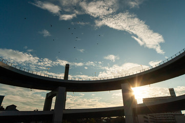 曲線的な道路と朝日の輝きと雲