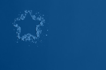 Star and snow on blue background. Christmas composition.