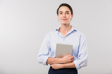 Young elegant businesswoman with touchpad standing in front of camera