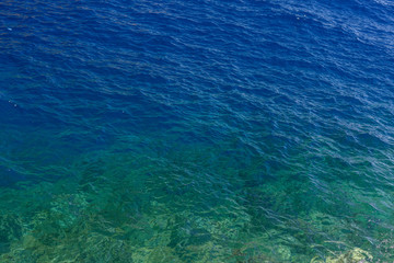 Deep blue sea water and underwater rocks near Hydra Island, Greece. Crystal clear sea water background in two colors. Horizontal